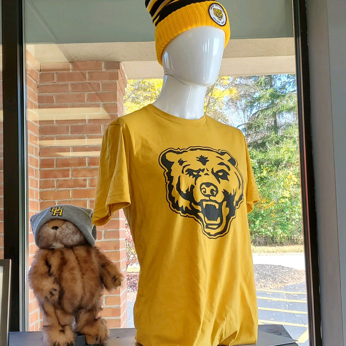 Show off your Upper Arlington Golden Bear Pride with this classic edition t-shirt. The officially licensed Golden Bear logo printed in black on a mustard t-shirt. Shown on a mannequin in The Shop. 